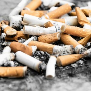 orange cigarette butts on black surface